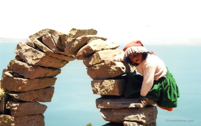 Isla Taquile girl climbing arch archway